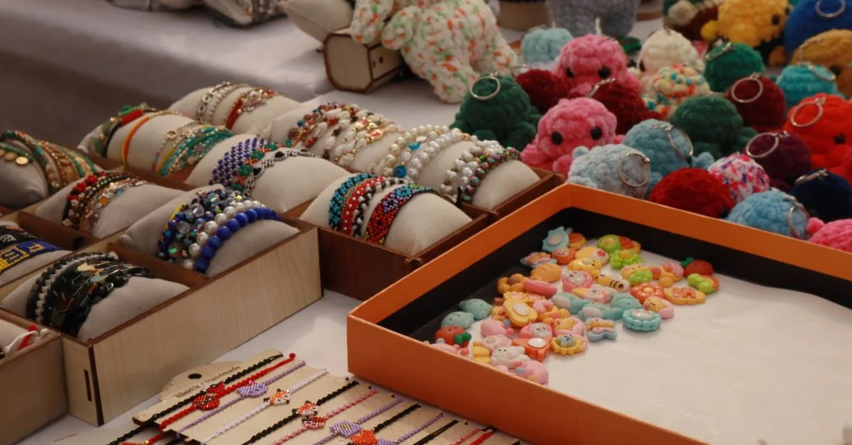 Un étal de marché regorgeant de bracelets faits main et de porte-clés au crochet.