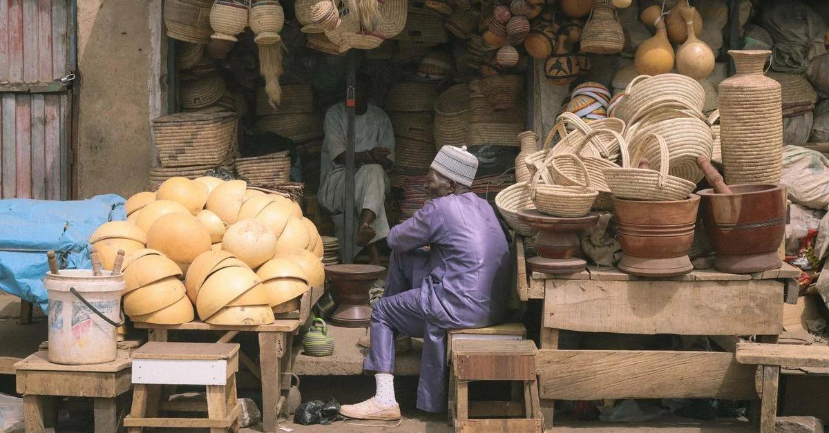 Une scène de marché animée affichant des paniers et des artisanats traditionnels à Kaduna, Nigeria.