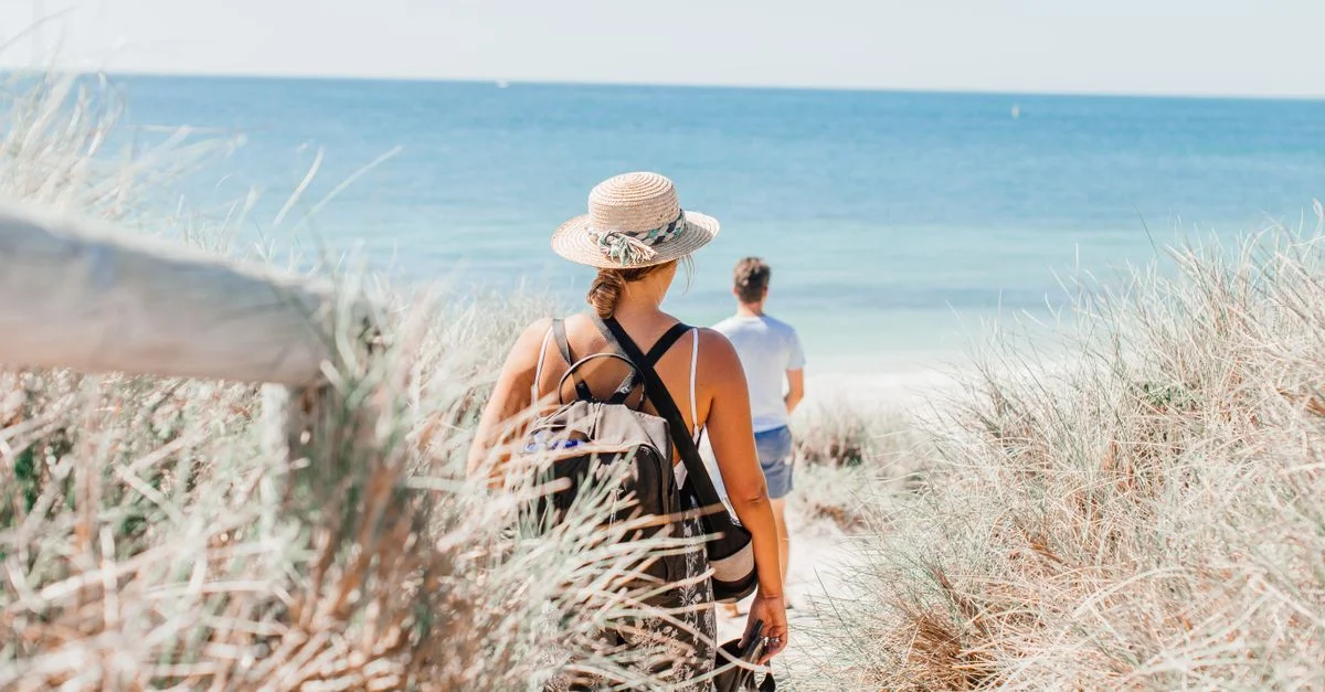 Une promenade tranquille sur une plage d'été ensoleillée, idéale pour un échappatoire de vacances relaxantes.