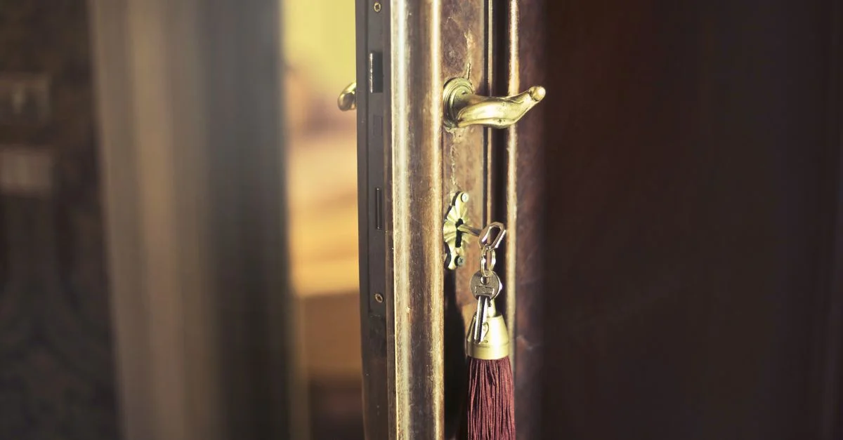 Gros plan sur une porte vintage avec une clé antique et un tissu, mettant en avant un design rustique.