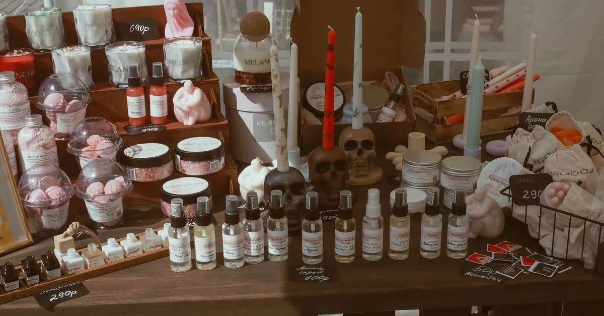 Présentation de bougies artisanales, d'articles de soins de la peau et de pièces décoratives sur un stand de marché.