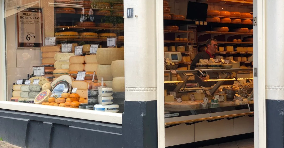 Une charmante fromagerie à Utrecht, avec un vendeur et des fromages artisanaux exposés.