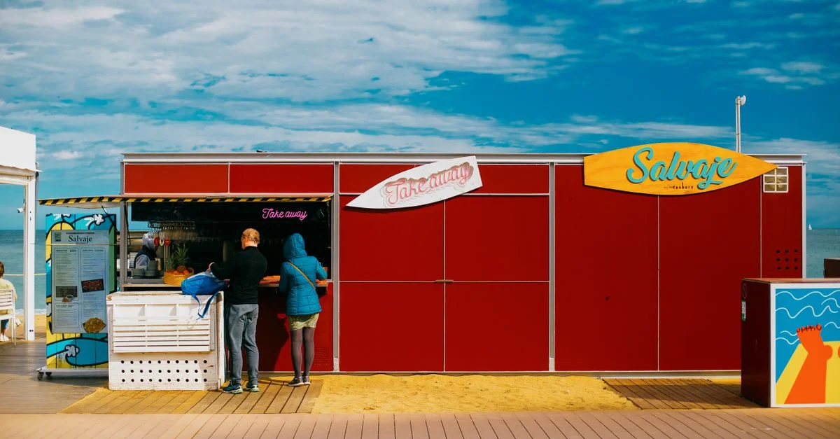 Scène de rue vibrante d'un kiosque de plats à emporter au bord de la plage à Barcelone, Espagne.
